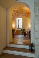 Un comedor con techo de ladrillo, una mesa dispuesta para cuatro personas y una escalera que conduce a un nivel superior.