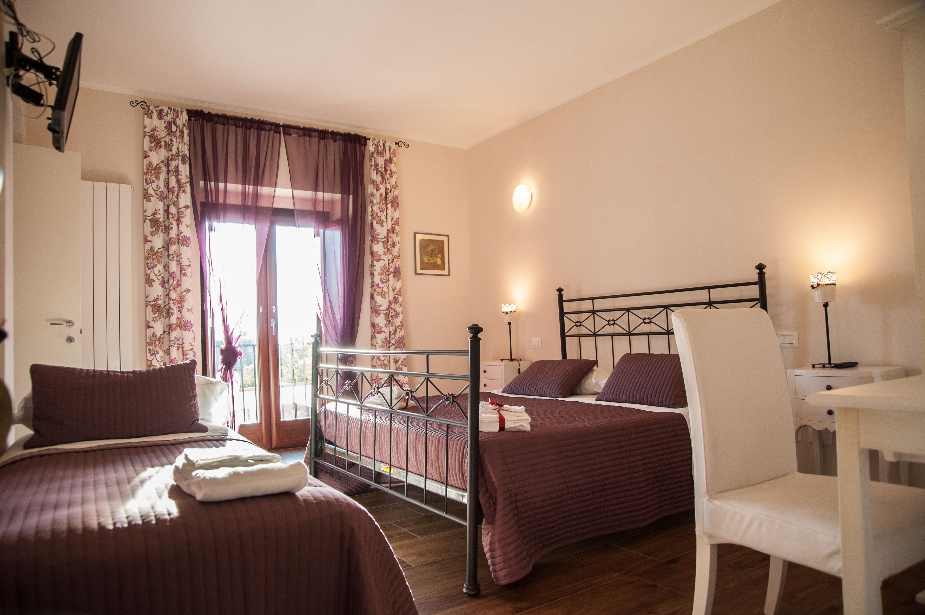 A bedroom with two beds, a desk, and a chair.