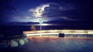 Una terrazza sul lungomare con un cartello, una bicicletta e una sedia.