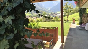 Área de estar coberta ao ar livre, com vista para uma paisagem montanhosa.