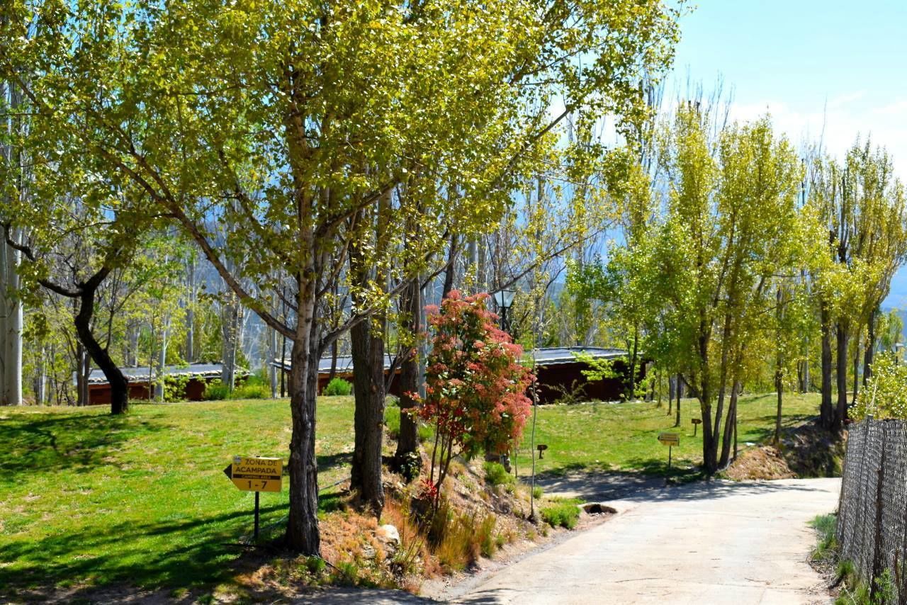Una strada rurale con un cartello che indica 'Zona de Acampada 1-7'.
