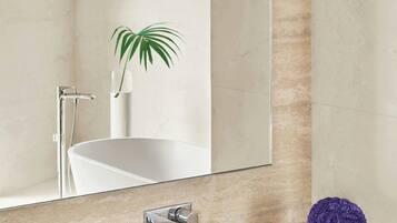 Un baño con un espejo grande, un lavabo y una planta.