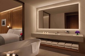 Een aparte badkuip en douche, designer toiletartikelen, een haardroger