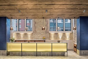 Une cuisine moderne avec un plafond en bois, de grandes fenêtres et un îlot central doté de sièges jaunes.