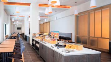 A modern breakfast bar with seating, a variety of food options, and a clean, contemporary design.