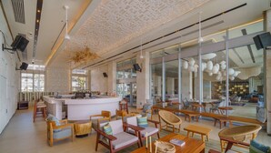 A modern hotel lobby with a central bar area, seating arrangements, and large windows offering views. - Renaissance Cancun Resort & Marina (Cancún)