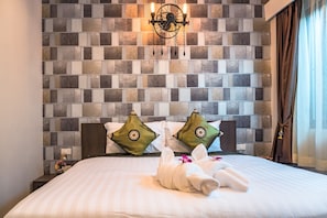 A hotel room with a tiled wall, a chandelier, a bed with white bedding, and two decorative pillows. - KG Private Pool Villas Soi Nine (Krabi)