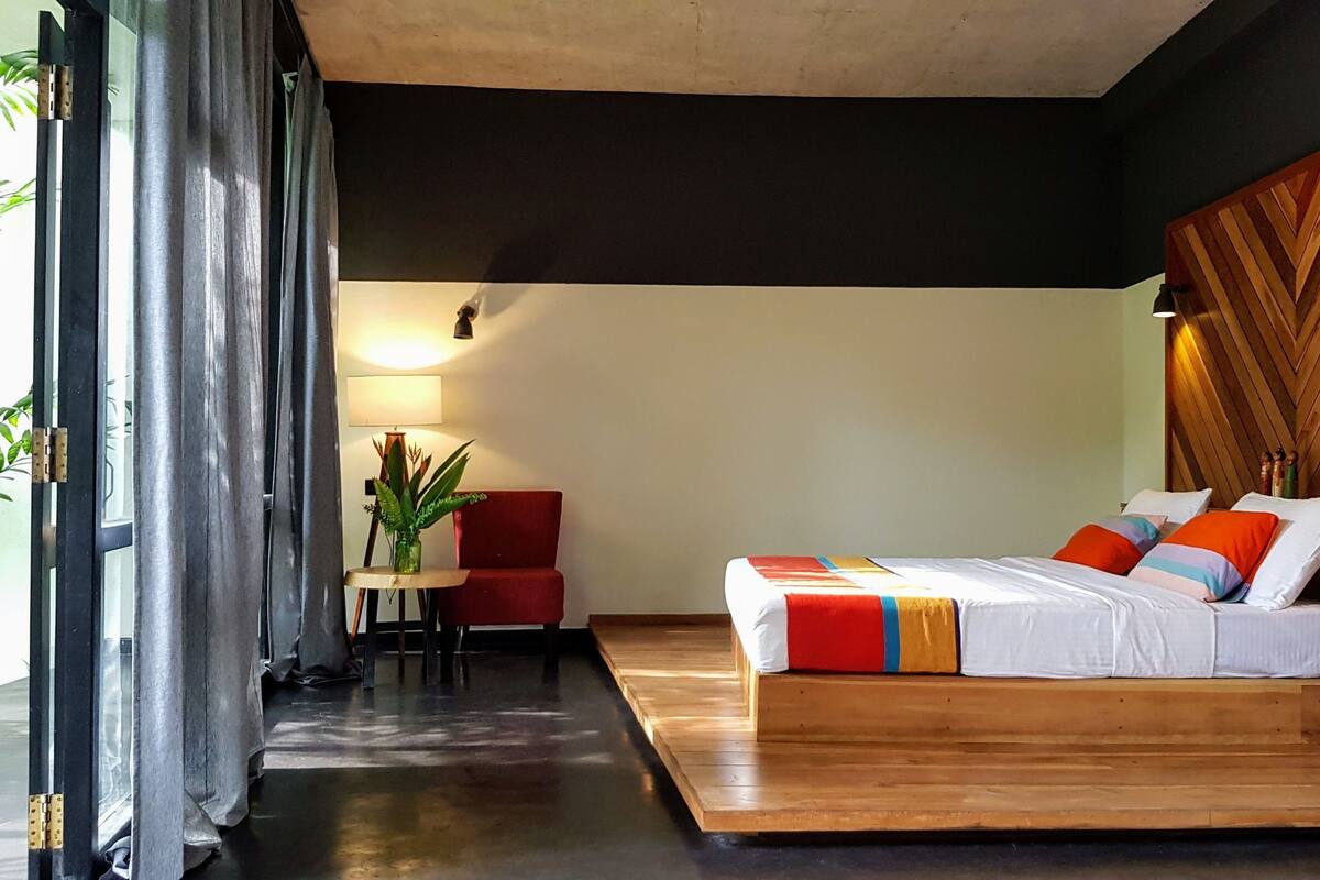 A modern bedroom with a bed, a desk, and a chair.