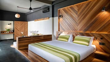 A modern bedroom with a herringbone-patterned headboard, a wooden bedside table, a bed with green-striped bedding, and a ceiling fan.