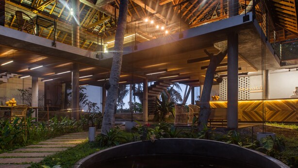 A modern building with a large open space, a central water feature, and a staircase leading to an upper level. - Lankavatara Ocean Retreat & Spa (Kalametiya)