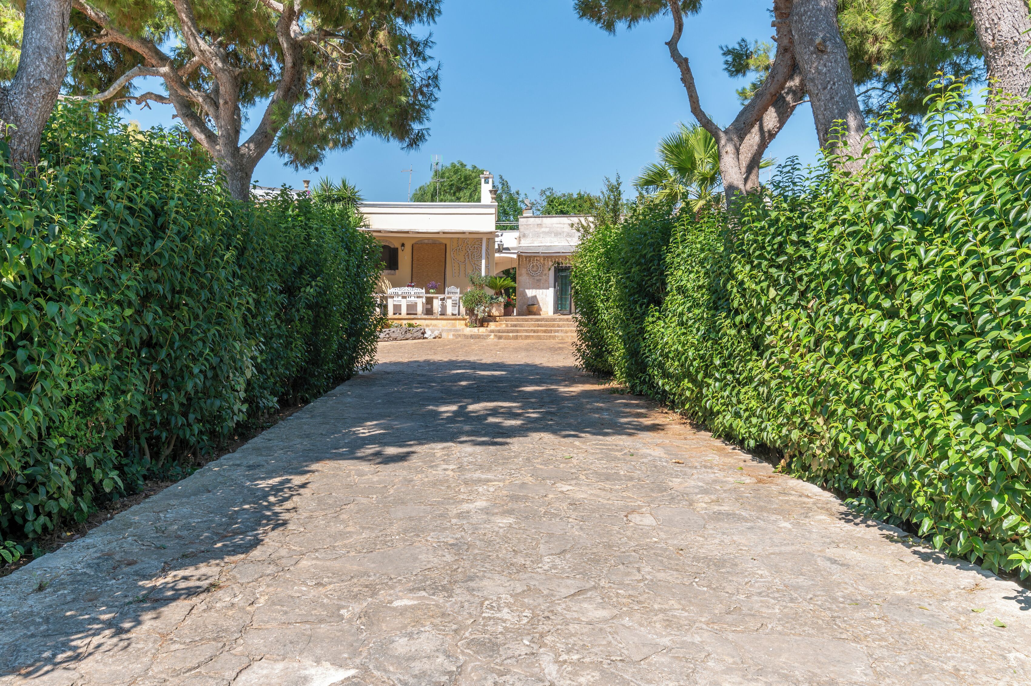 A stone pathway leading to a building with a covered patio area.