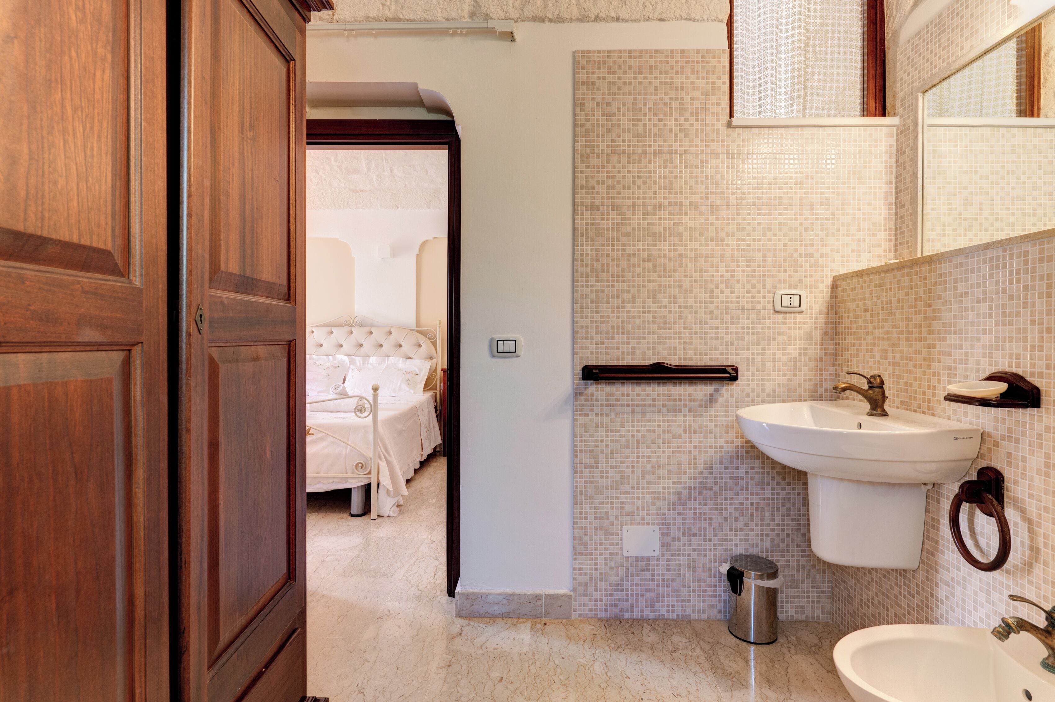 Une salle de bain avec un lavabo blanc, un miroir et des toilettes.
