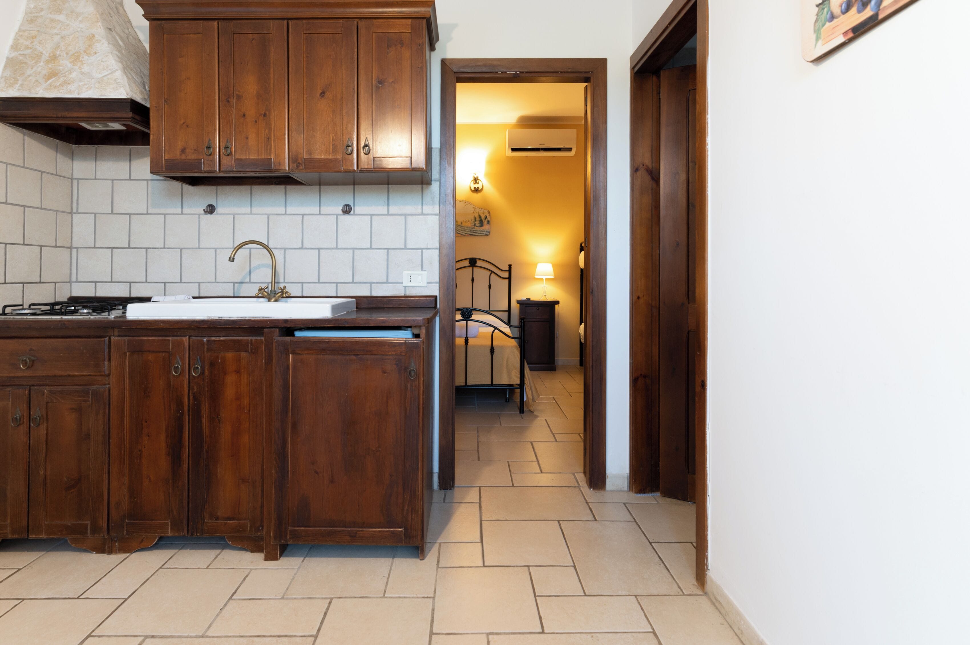 Une cuisine avec des meubles de rangement en bois, un évier et une cuisinière.