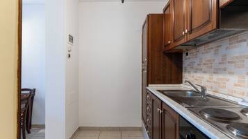 A kitchen with wooden cabinets, a stainless steel sink, and a tiled backsplash.