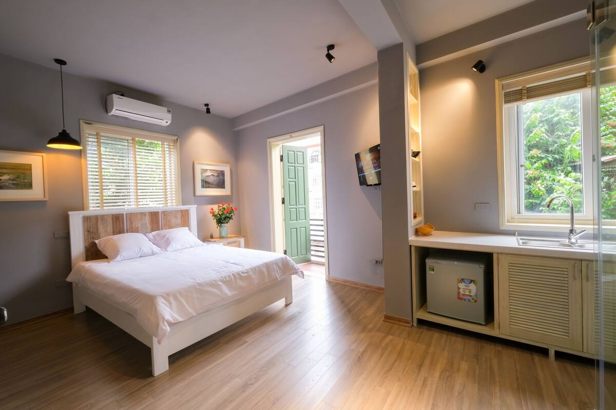 Un dormitorio con cama, mesita de noche y un refrigerador pequeño.