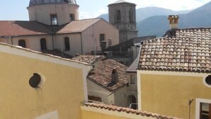 Vista de un pueblo histórico con arquitectura tradicional, que incluye una cúpula destacada y un campanario, además de un edificio amarillo con ventanas de arco.