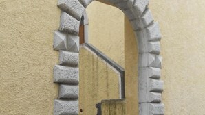 Un arco de piedra que da acceso a una serie de escalones de piedra.