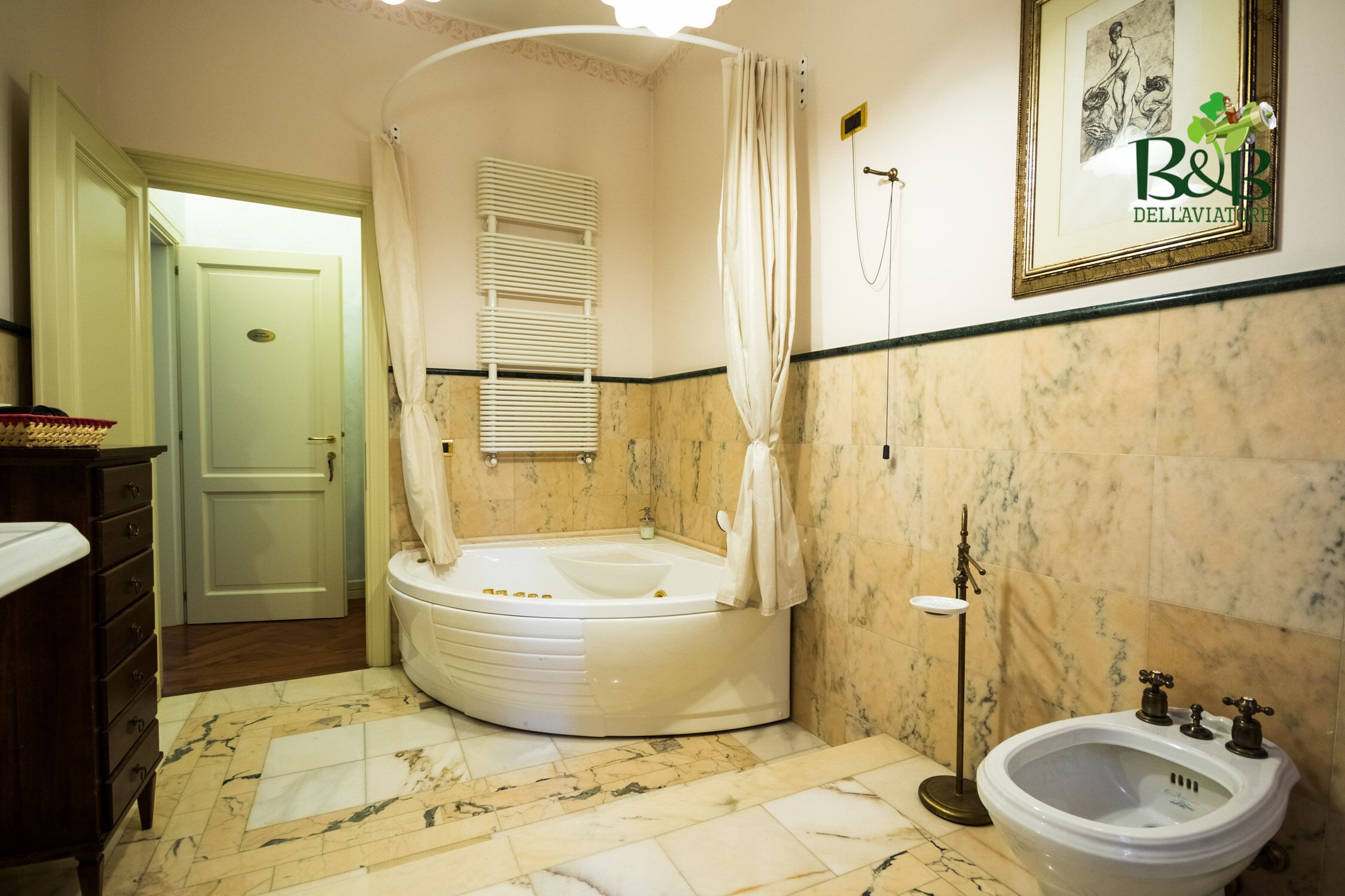 Un bany amb banyera independent, un lavabo i un escurapous.