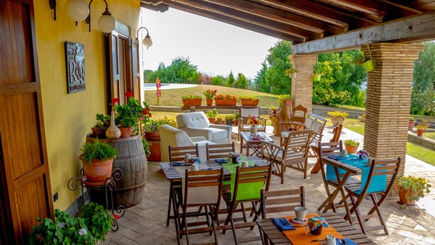 Une terrasse extérieure avec des meubles en bois et des plantes en pot.
