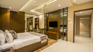 Una habitación de hotel moderna con una cama grande, un escritorio, un armario y un televisor.