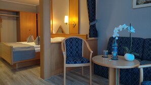 A hotel room with a bed, a chair, a small table, and a sofa. - Hotel Zum Märchenwald (Lingen)