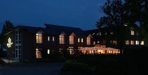 A large, multi-story building with a prominent entrance and a series of windows. - Hotel Zum Märchenwald (Lingen)