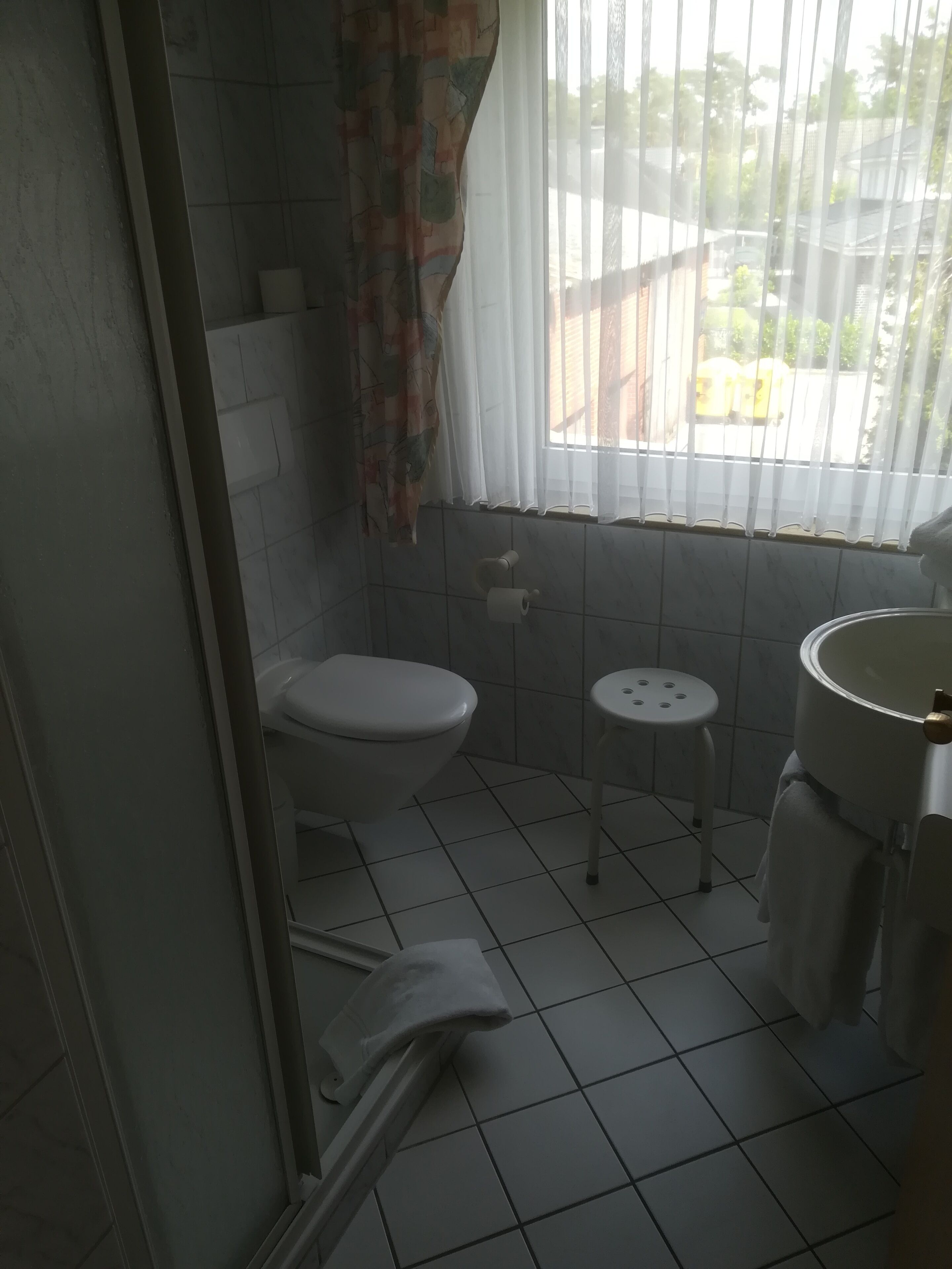 Un baño con inodoro, lavamanos y ventana.