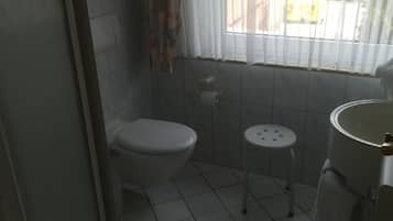 Un baño con inodoro, lavamanos y ventana.
