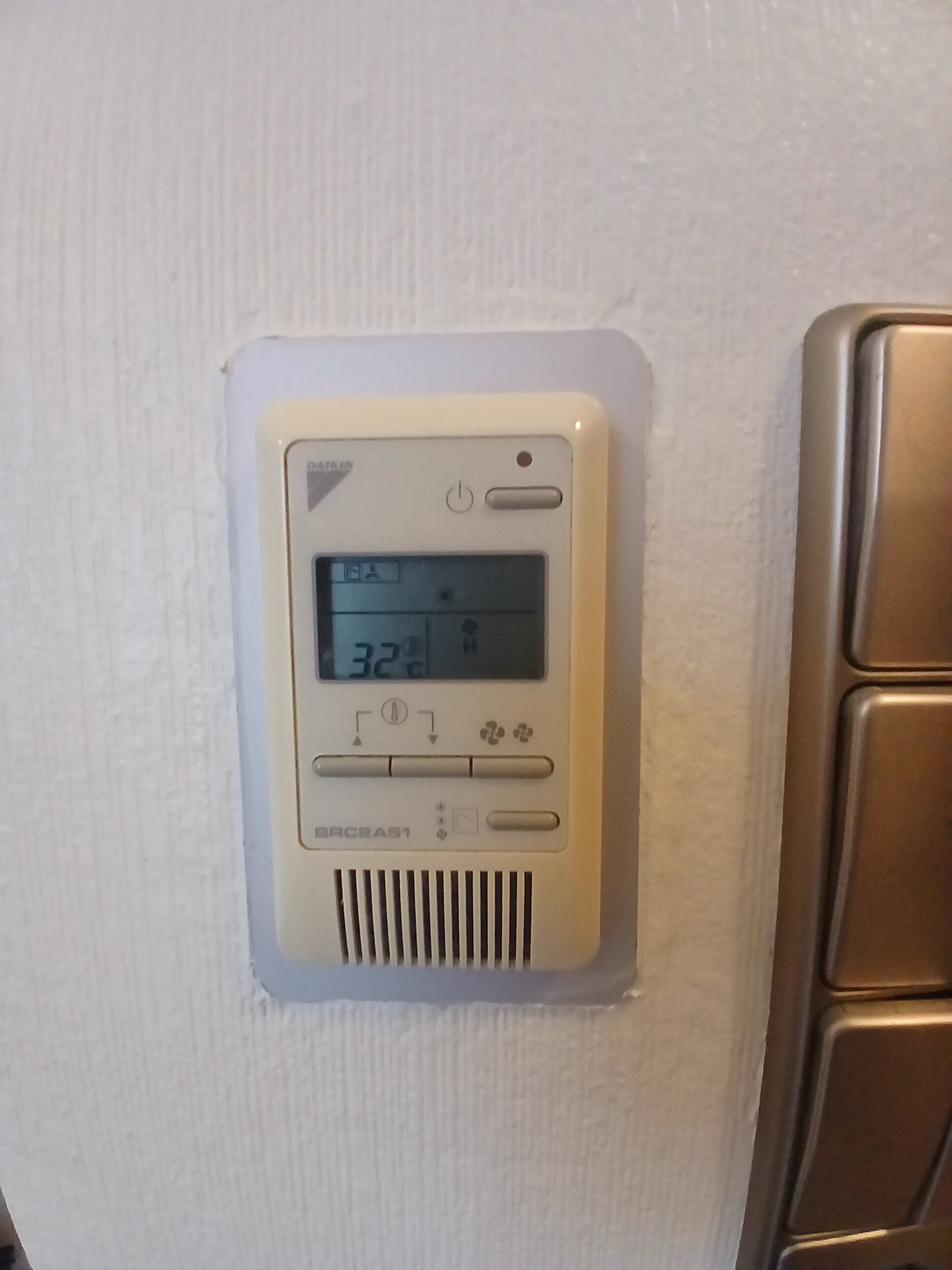 Termostato instalado en la pared, con pantalla digital que muestra la temperatura.