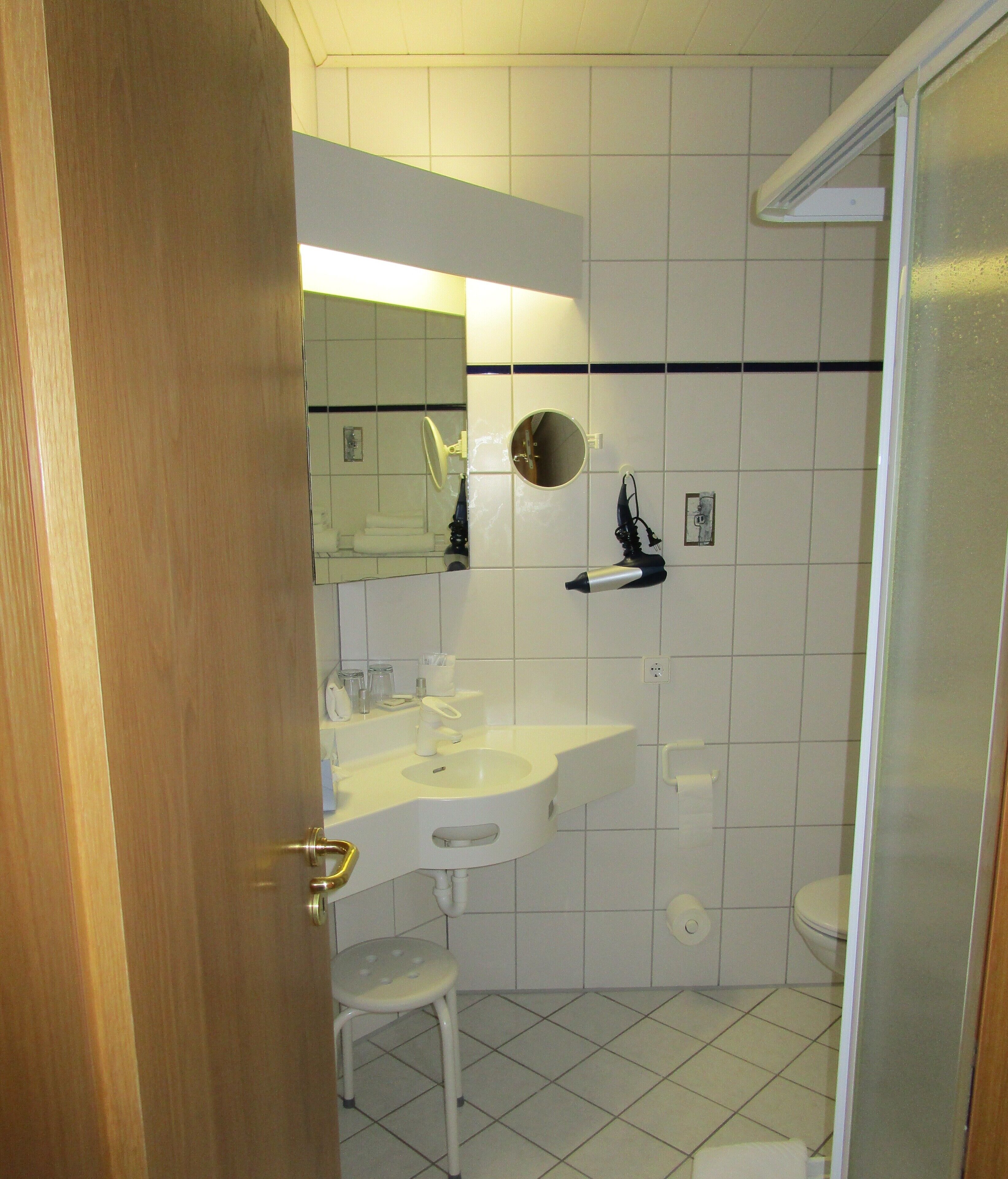 A bathroom with a white sink, mirror, and toilet.