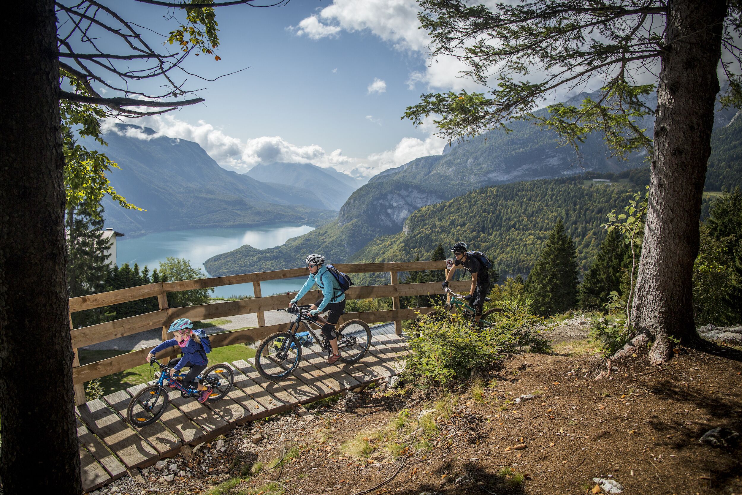 A wooden bridge with a scenic view of a lake and mountains.