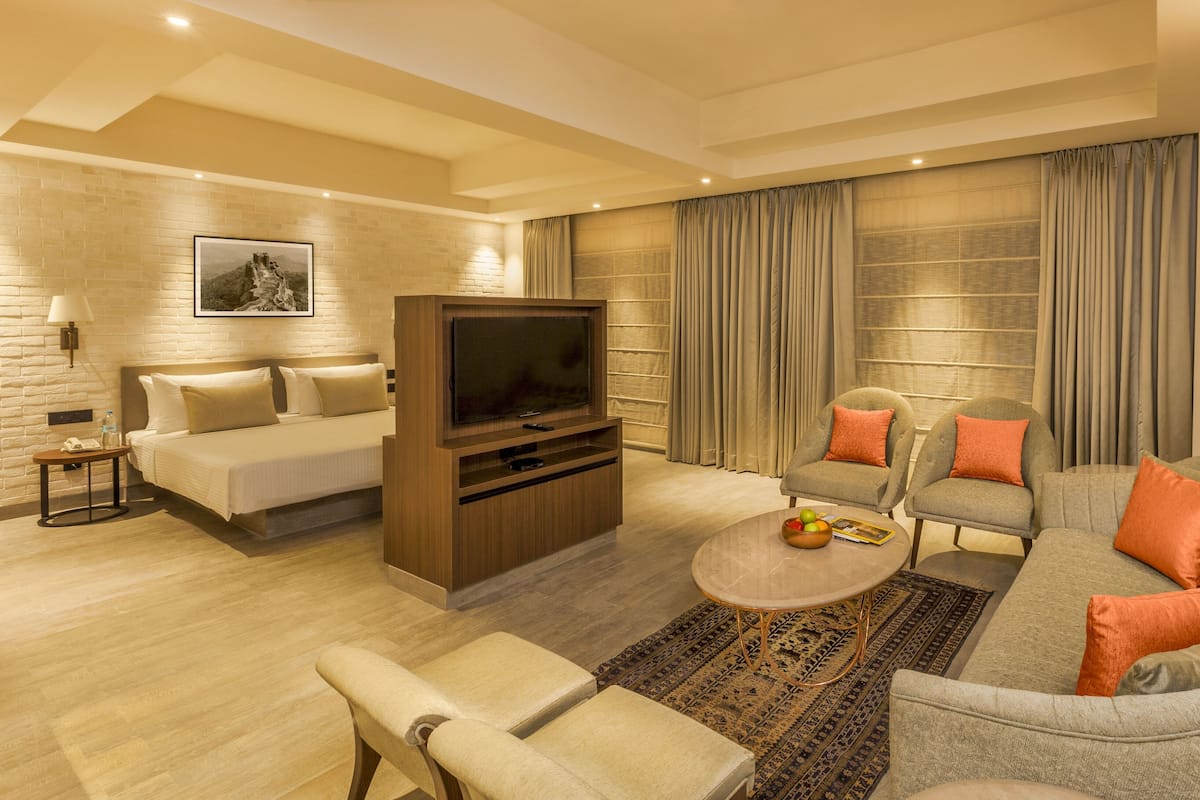A modern living room with a sofa, armchairs, a coffee table, and a TV.