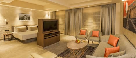 Una sala moderna con un sofá, sillones, una mesa de centro y un televisor.