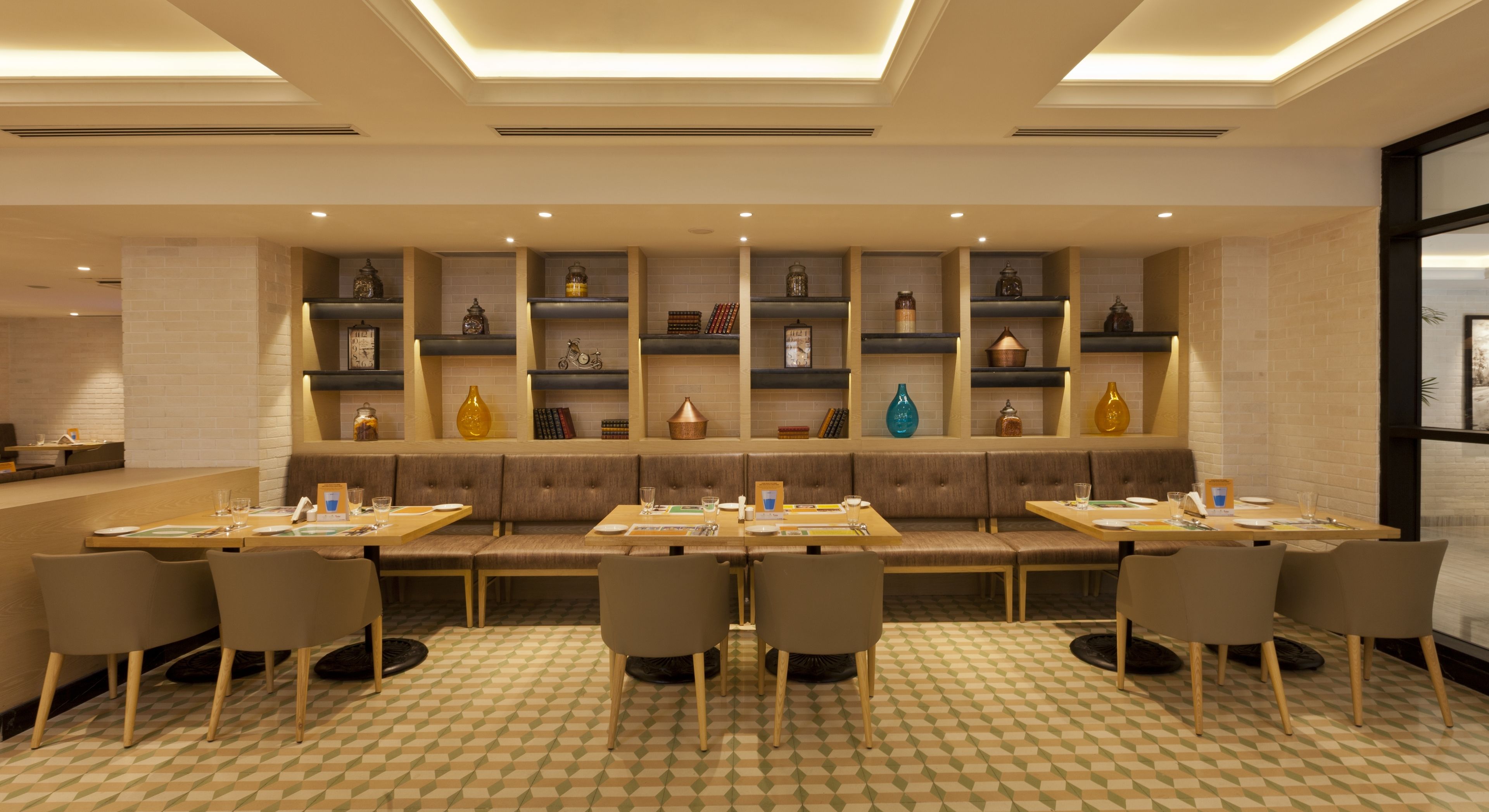 A restaurant with a long counter, booths, and shelves with decorative items.
