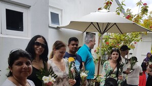 A group of people standing outdoors, some holding flowers. - Goby Lodge Guest House (Mahibadhoo)