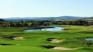 Un campo de golf con numerosos búnkeres y un estanque.