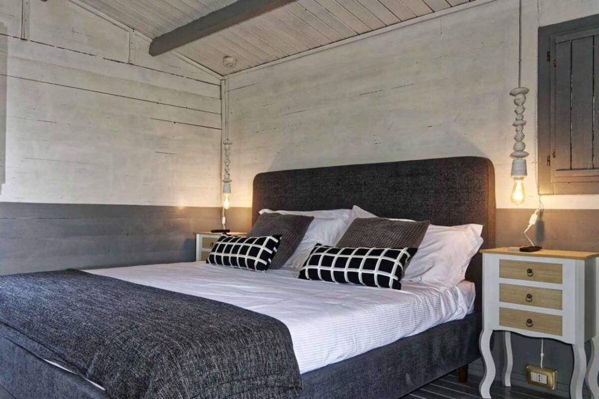 Une chambre à coucher avec un grand lit, deux tables de chevet et une porte en bois.