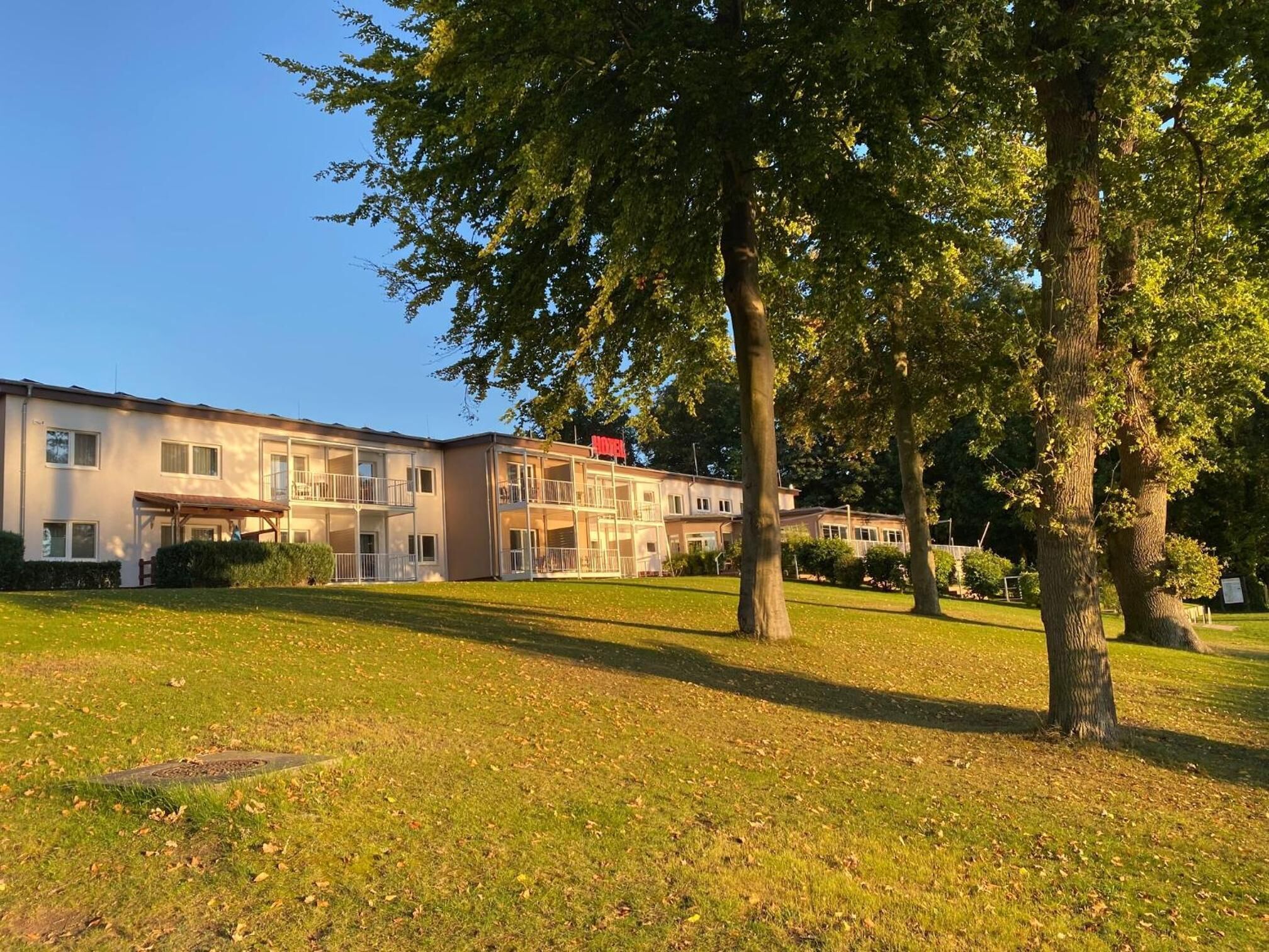 Um hotel com vários andares, varandas e um gramado bem cuidado.