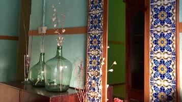 Una habitación con un espejo grande, un armario de madera y un muro con azulejos.