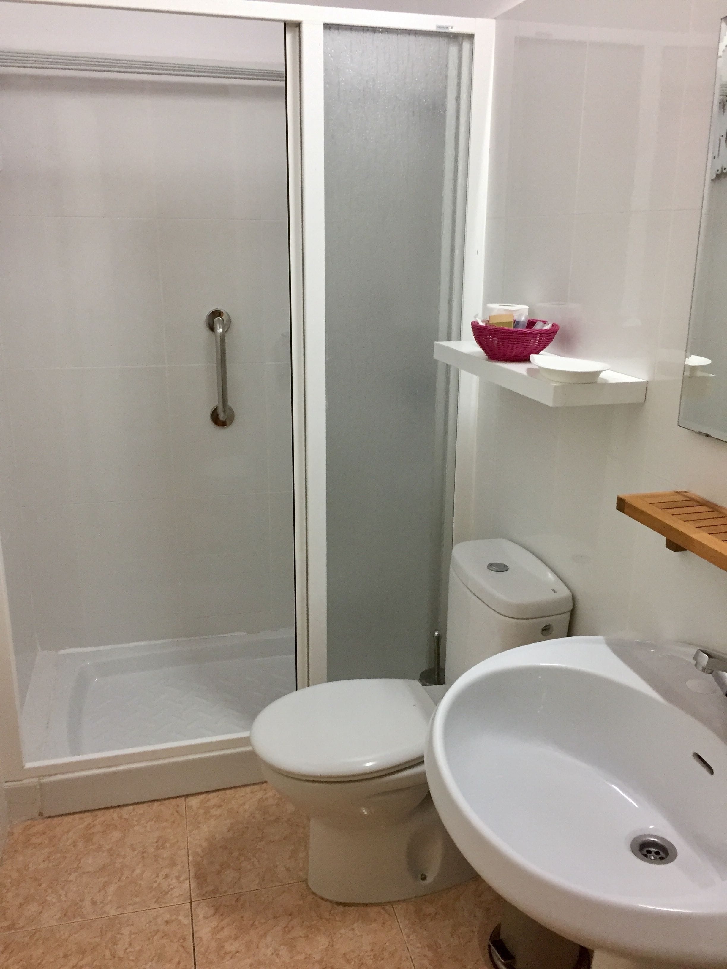 A bathroom with a shower, toilet, and sink.