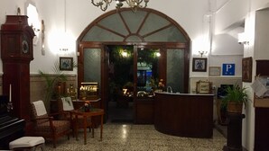 Un hall d’entrée avec un comptoir de réception, un espace salon et une grande horloge.