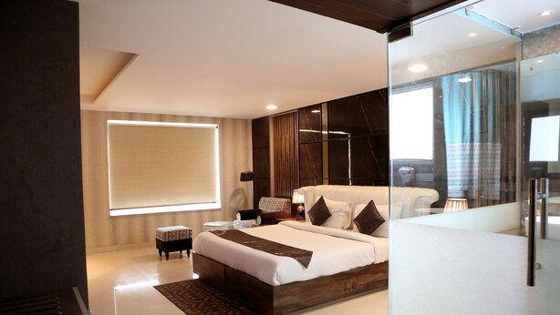 Un dormitorio moderno con una cama grande, un separador de vidrio y vistas al exterior.