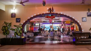 Un espacio interior con una recepción, asientos y una zona de bar.
