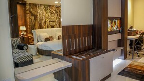 Una habitación de hotel moderna con una cama grande, un sofá, un escritorio y un televisor.