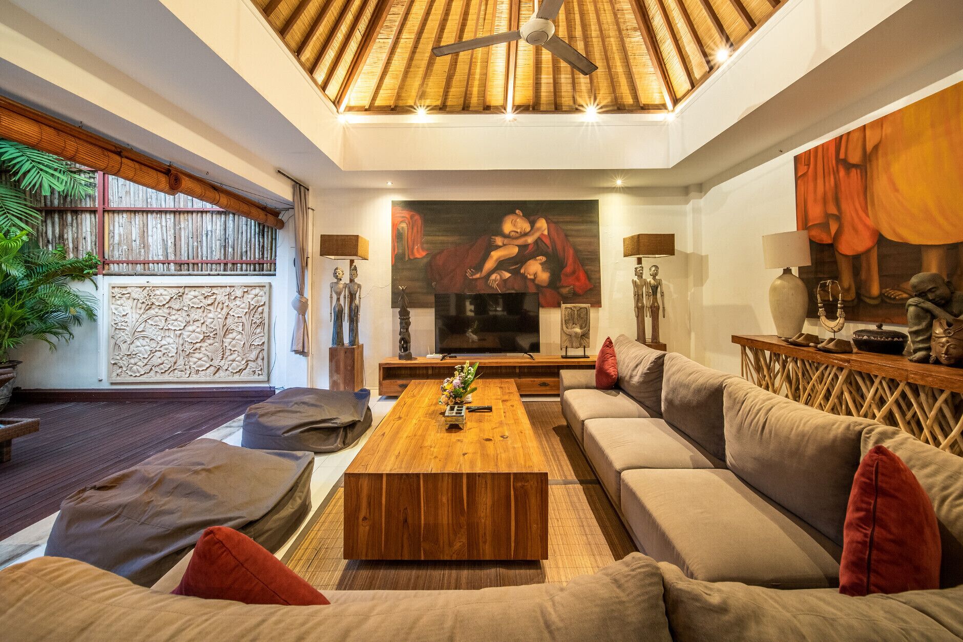 Un salon avec un plafond en bois, un grand tableau et un ensemble de meubles de salon (canapé, fauteuils, etc.).