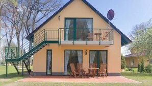 A two-story building with a balcony, a satellite dish, and outdoor furniture. - Mueritz Landhausperle (Röbel/Müritz)