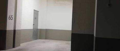 A hallway with a door marked 64, a door marked 65, and a concrete floor.