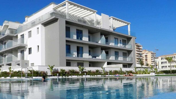 A modern building with a swimming pool in front. - Panorama Beach Apartment - Torrox Costa (Torrox-Costa)