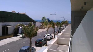 A coastal street with parked cars, palm trees, and a clear view of the sea. - Panorama Beach Apartment - Torrox Costa (Torrox-Costa)