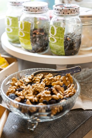 A bowl of mixed nuts and dried fruits on a tray.